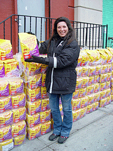 Mindy Appleman, a volunteer feral cat caretaker from Queens, picks up Meow Mix at the cat food giveaway. (Photo by Meredith Weiss)