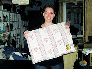 Rational Animal volunteer Michelle Aptman shows off a cage comforter stitched at a Mother's Comfort Project sewing event.