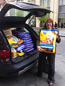 Volunteer Cathy Browne loads donated Pedigree dog food into her car to take to the Rockaways for distribution. (Photo by Evon Handras)